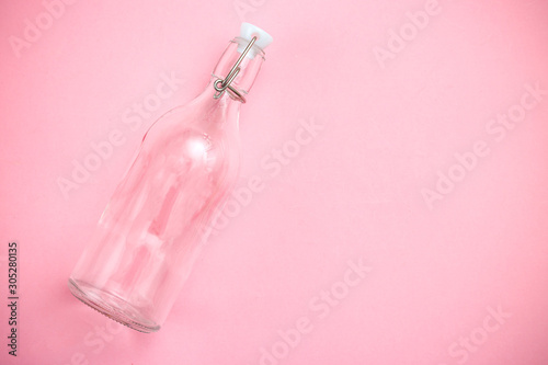 Reusable bottle on pink background. Glass bottle. Copy space. Retro © _nastassia