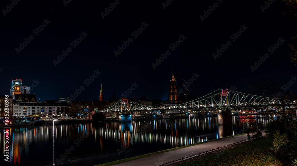 frankfurt city with cathedral at night with colorful reflections in the main river, frankfurt am main, germany