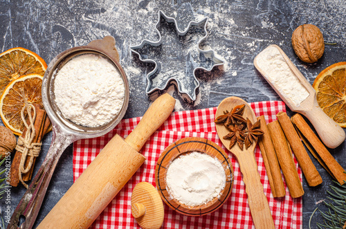 ngredients for cooking Christmas baking. Baking background with flour and rolling pin, wooden utensils. Preparation for the holiday. Top view, copy space.