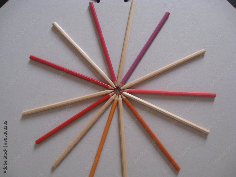 Lápices de puntas de colores de distinta fabricación en madera natural y en madera pintada de gamas de rojos naranjas y rosas haciendo círculo Lápices de puntas de colores de distinta fabricación en madera natural y en madera pintada de gamas de rojos naranjas y rosas haciendo círculo
