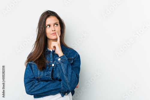 Young cute woman looking sideways with doubtful and skeptical expression. photo