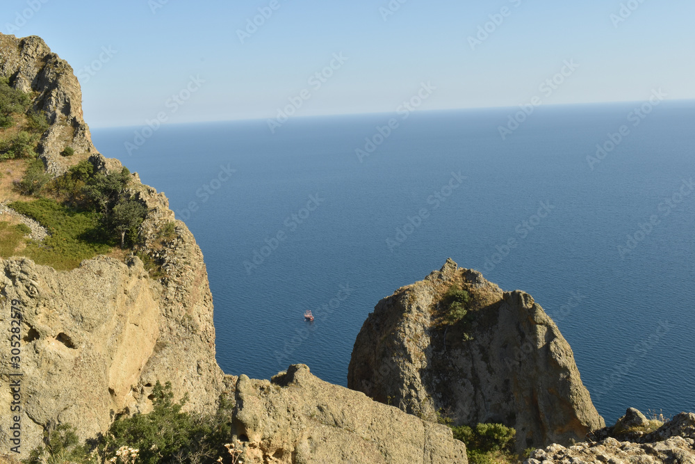 View from the rocks to the ship at sea and clear sky