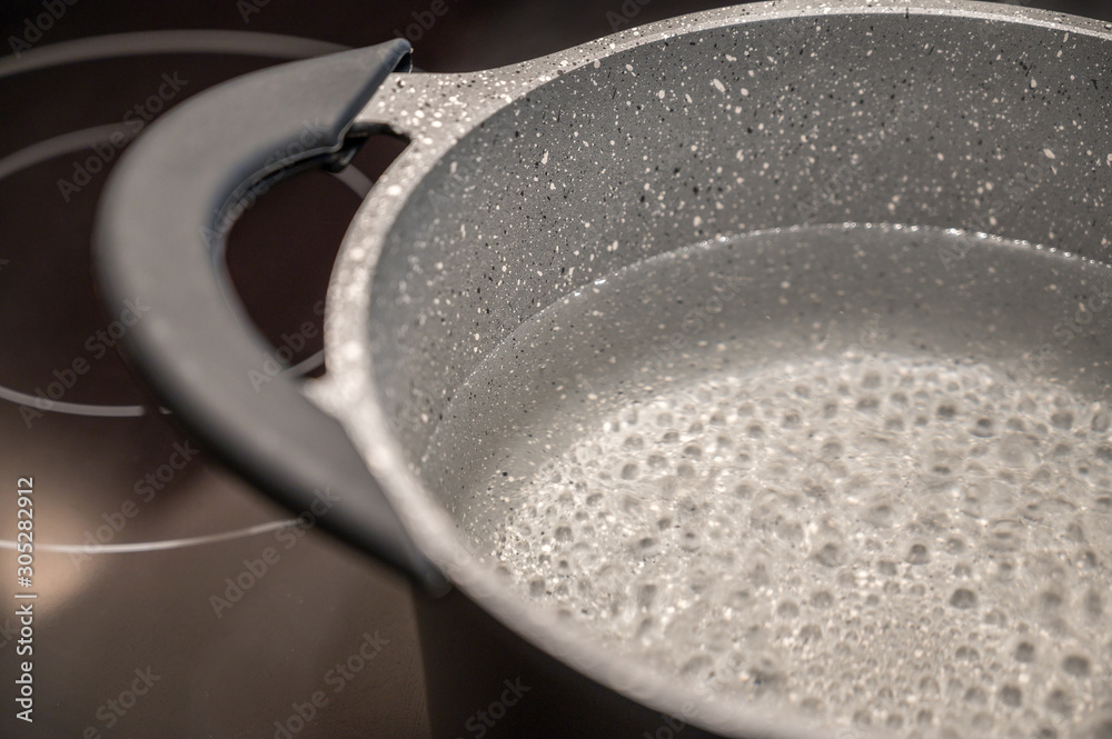 Kochendes Wasser in einem Kochtopf auf einem Induktionsherd Kochendes Wasser in einem Kochtopf auf einem Induktionsherd