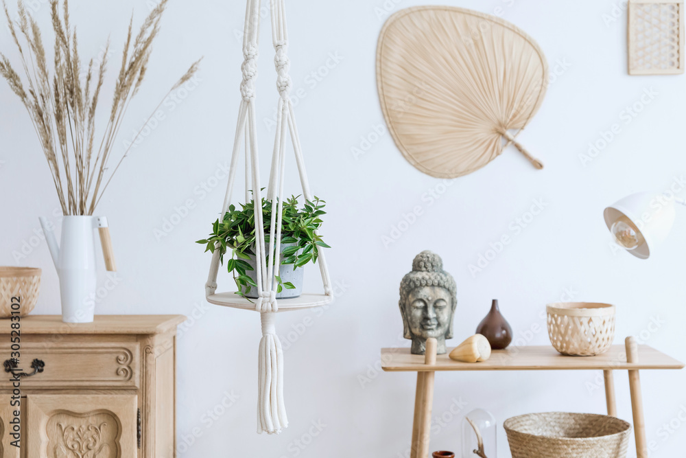 Minimalistic boho interior with design and handmade macrame shelf planter hanger for indoor plants, wooden furnitures, elegant accessories ,rattan basket and leaf. Cozy home decor of living room.  - obrazy, fototapety, plakaty 