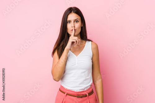 Young cute woman keeping a secret or asking for silence.
