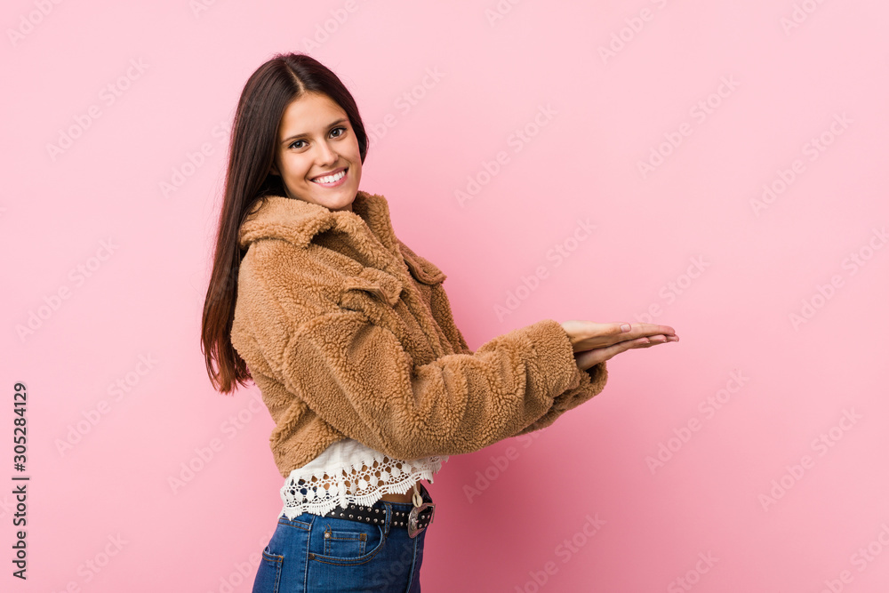 Young cute woman holding a copy space on a palm. Young cute woman holding a copy space on a palm.