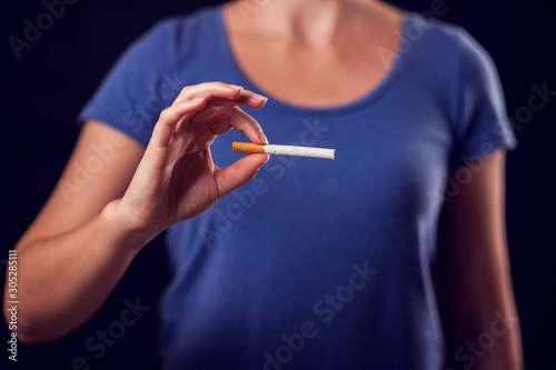 Woman holding cigarette in hands. Stop smoking concept