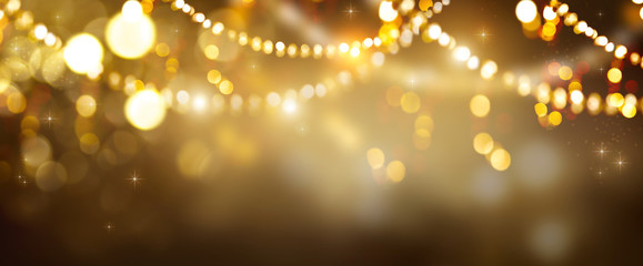 Christmas Gold glowing Background. Golden Holiday Abstract Glitter Defocused Backdrop With Blinking Stars and garlands. Tinsel Blurred gold Bokeh on black background. Festive defocused elegant border