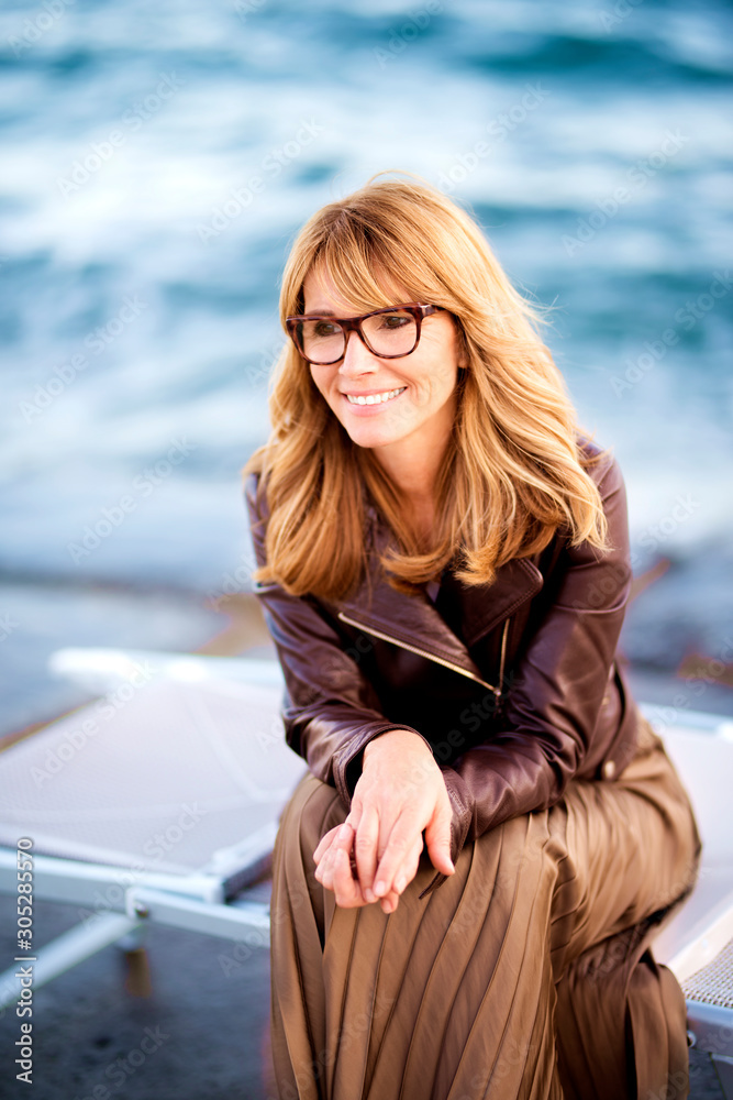 Portrait of beautiful woman sitting by the sea Portrait of beautiful woman sitting by the sea