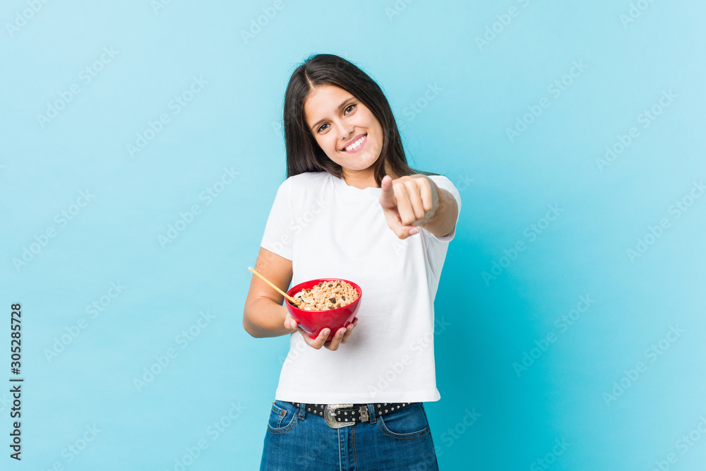 Young caucasian woman holding a cereals bowl cheerful smiles pointing to front. Young caucasian woman holding a cereals bowl cheerful smiles pointing to front.