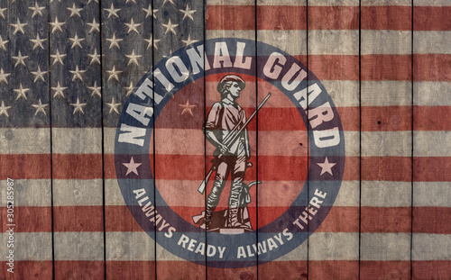 vintage american flag and national guard insignia painted on an old barn wall