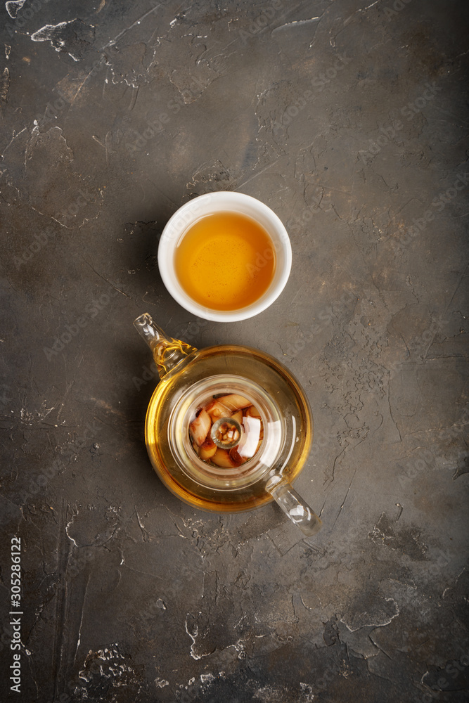 Healthy antioxidant and anti-inflammatory tea with fresh ingredients ginger, lemongrass, sage, honey and lemon on dark background with copy space. Top view.