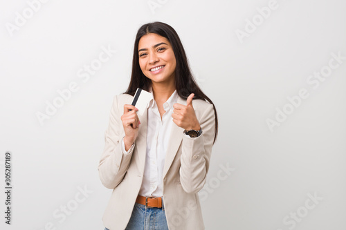 Quadro su tela Young arab woman holding a credit card smiling and raising thumb up