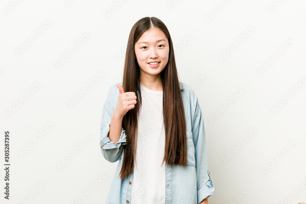 Young asian woman smiling and raising thumb up Young asian woman smiling and raising thumb up