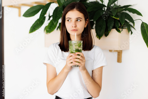 Foto Young woman drinking fresh drink in cafe