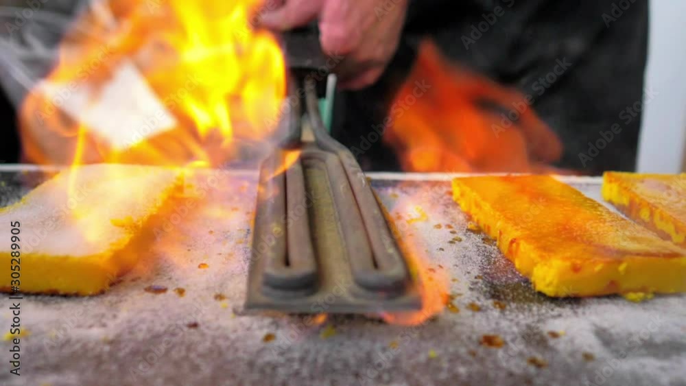 Plancha de cocinero en primer plano quemando azúcar turrón de yema