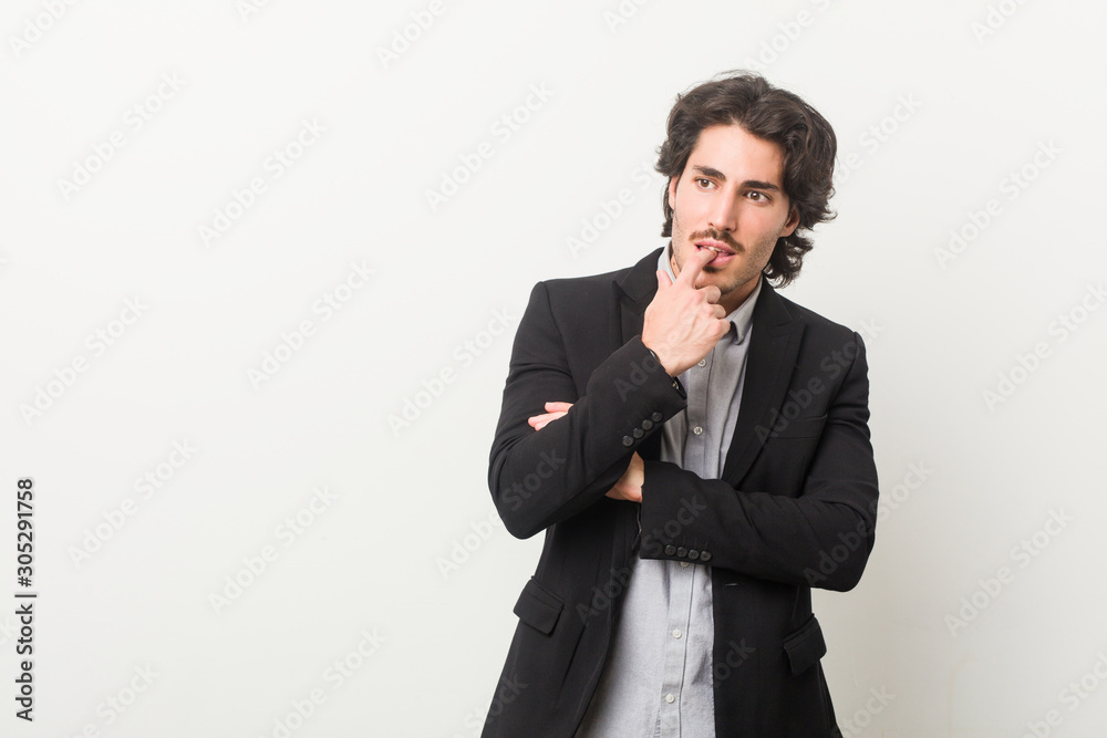 Young business man against a white background relaxed thinking about something looking at a copy space. Young business man against a white background relaxed thinking about something looking at a copy space.