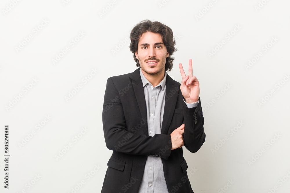 Young business man against a white background showing number two with fingers. Young business man against a white background showing number two with fingers.