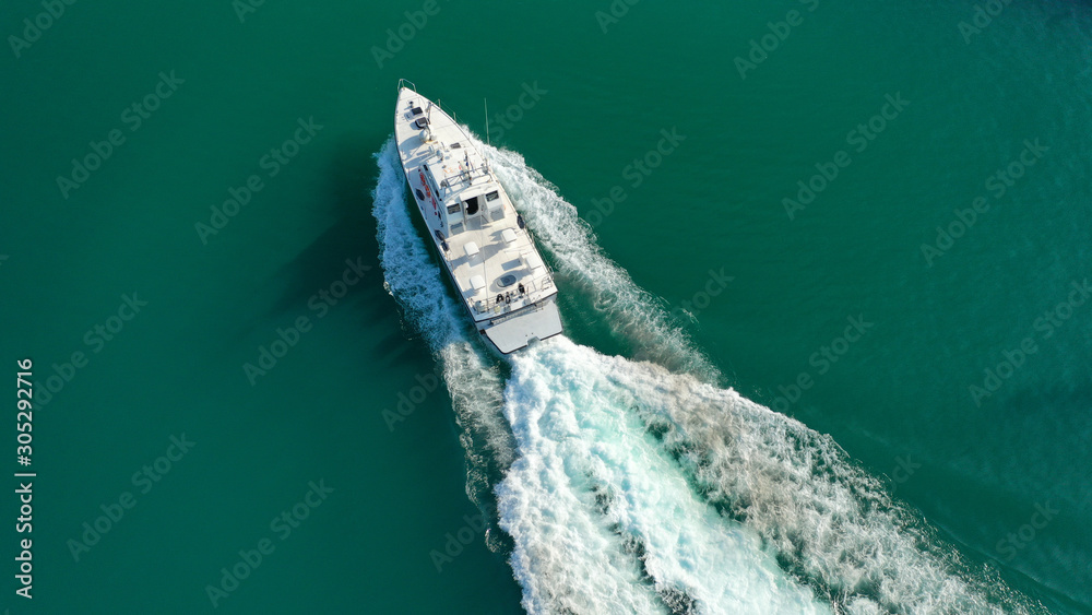 Aerial drone photo of speed boat cruising in high speed in Mediterranean lake with emerald water