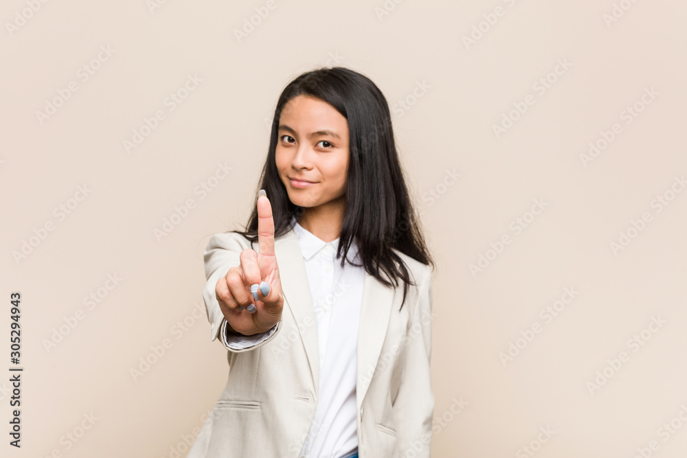 Young business chinese woman showing number one with finger. Young business chinese woman showing number one with finger.
