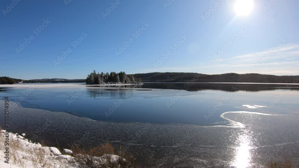 Algonquin Provincial Park with partly frozen iconic island in Lake of Two Rivers in a sunny winter day. Panning and hand held Algonquin Provincial Park with partly frozen iconic island in Lake of Two Rivers in a sunny winter day. Panning and hand held