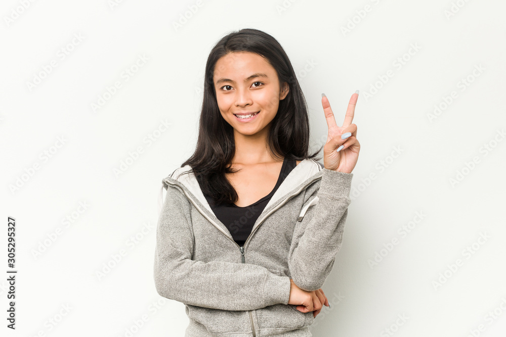 Young fitness chinese woman showing number two with fingers. Young fitness chinese woman showing number two with fingers.
