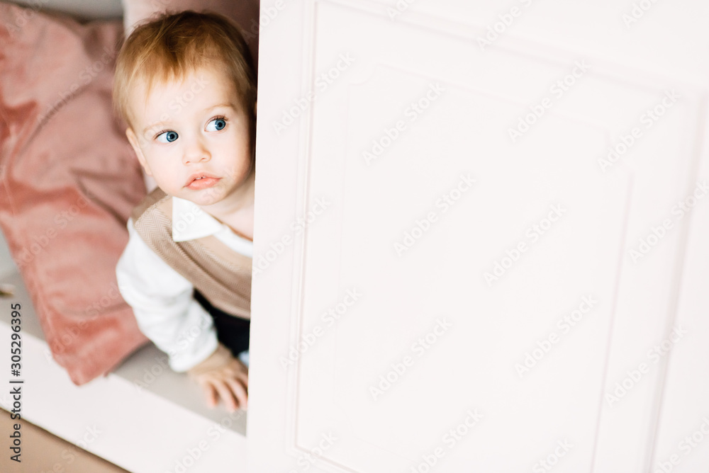 small child plays alone in his room, the boy is hiding in the closet small child plays alone in his room, the boy is hiding in the closet