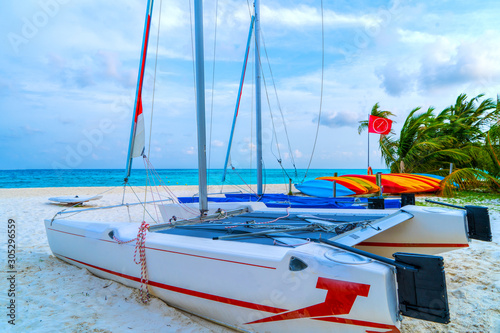 Boats for water activities in the Maldives lie on the shore in t