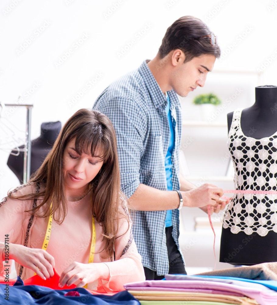 Male tailor with female student in workshop Male tailor with female student in workshop
