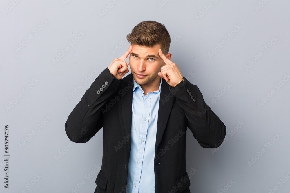 Young handsome caucasian man focused on a task, keeping forefingers pointing head. Young handsome caucasian man focused on a task, keeping forefingers pointing head.