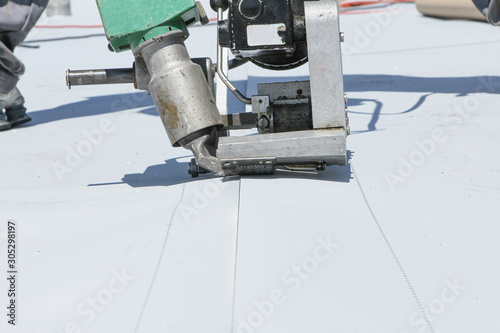 roofer joining white plastic sheets