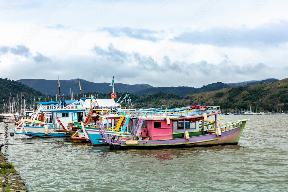 Tourist boat dock in Paraty Bay in Rio de Janeiro, Brazil, where passenger boats await customers to be taken to nearby islands or other villages. world heritage