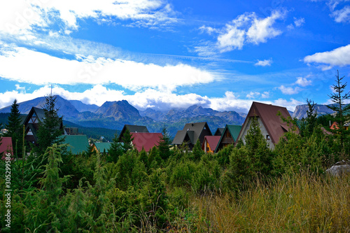 Colored roofs, trees and mountains. © Tsiana