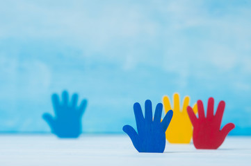 Colorfull puzzles hands on blue background. World Autism Awareness Day Concept