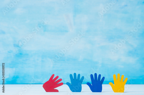 Colorfull puzzles hands on blue background. World Autism Awareness Day Concept photo