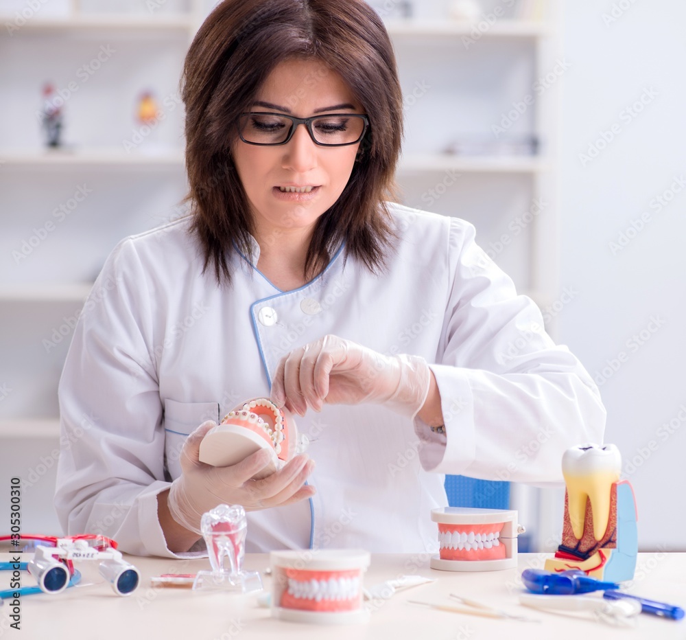 Woman dentist working on teeth implant Woman dentist working on teeth implant