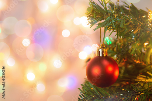 Christmas decoration. Hanging red balls on pine branches Christmas tree garland and ornaments over abstract bokeh background with copy space.