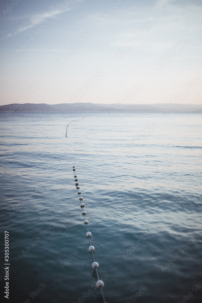 Calm background with views of the sea and the far shore. dividing buoys in the swimming area. Calm background with views of the sea and the far shore. dividing buoys in the swimming area.