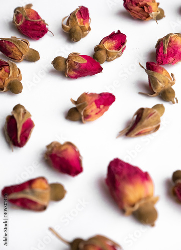 Dry tea rose buds on a white background in the shape of a heart