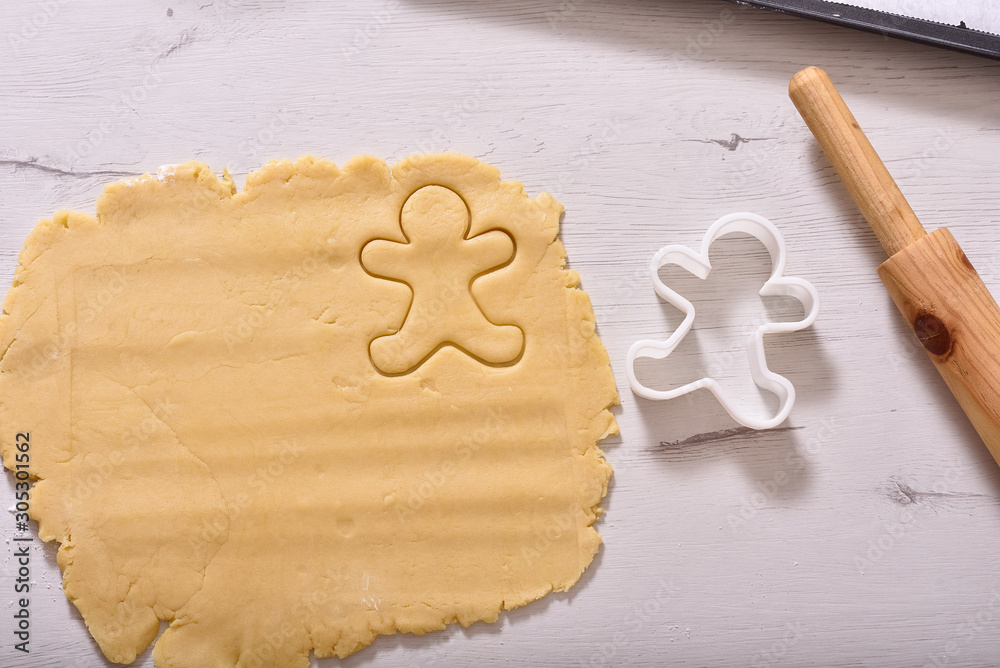Christmas and New Year celebration traditions. Family home bakery, cooking traditional festive sweets. Woman cutting cookies of raw gingerbread dough Christmas and New Year celebration traditions. Family home bakery, cooking traditional festive sweets. Woman cutting cookies of raw gingerbread dough