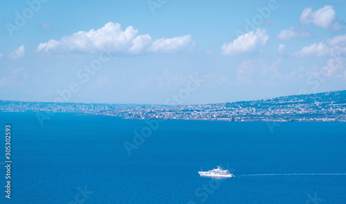 Fototapeta Naklejka Na Ścianę i Meble -  Aerial view on sea with sailing yacht and Pompei city on background.