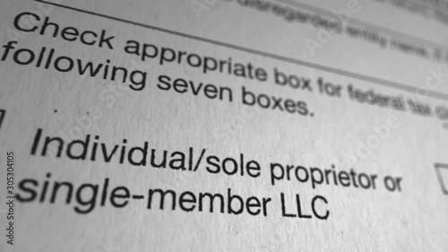 W-9 Fed Tax Classification Document. Macro shot flies across several check boxes for individual, sole proprietor, type of corporation, partnership, or trust.