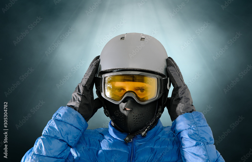 Skier wearing a ski helmet, google, gloves and a winter jacket. Concept of skiing, snowboarding. Winter sports.