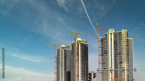 Generic two buildings under construction  with modern high rise towers building with tower cranes and unfinished exteriors photo