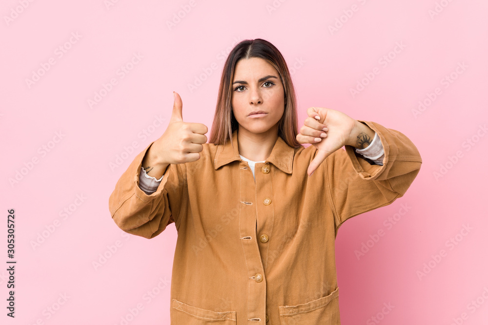 Young caucasian woman isolated showing thumbs up and thumbs down, difficult choose concept Young caucasian woman isolated showing thumbs up and thumbs down, difficult choose concept