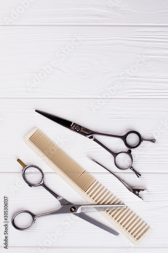 Hairdressing scissors and comb  top view. Professional barbers tools on white background. Space for text.