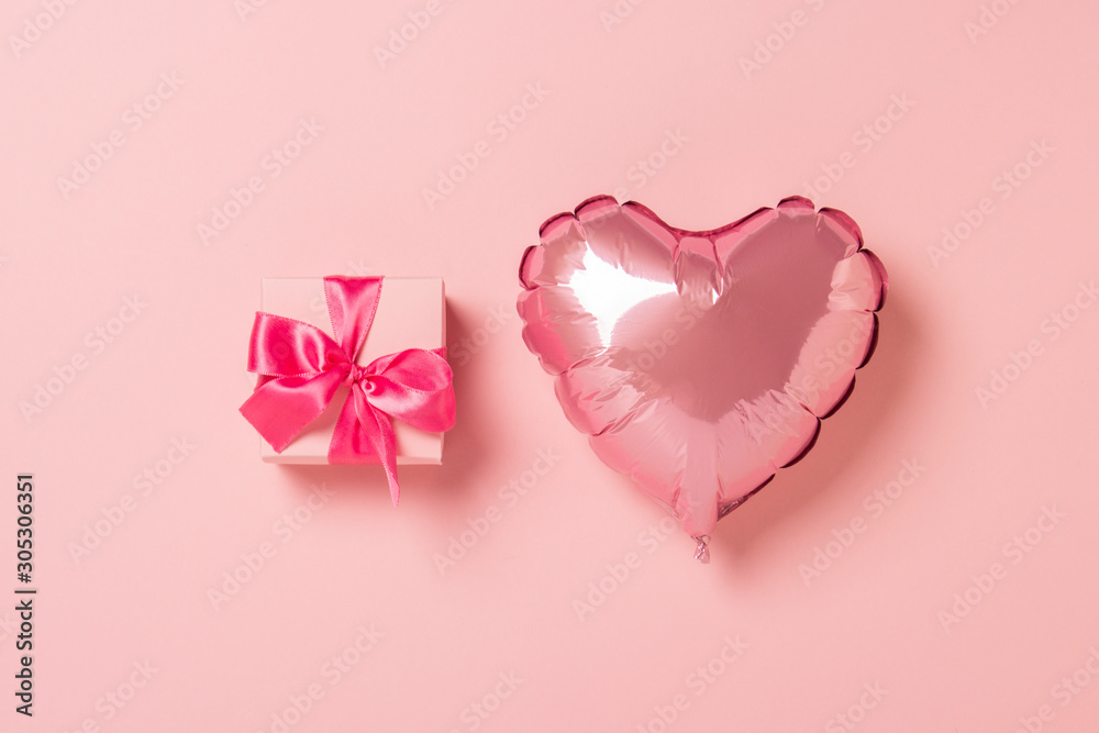 Pink air balloon heart shape Pink gift box with pink ribbon on a pink background. Wedding concept, Valentine's Day, a gift for a loved one. Flat lay, top view