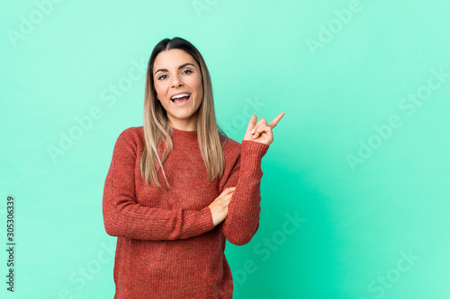 Young caucasian woman isolated smiling cheerfully pointing with forefinger away.