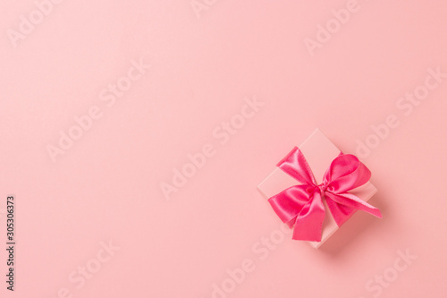 Pink gift box with pink ribbon on a pink background. Wedding concept  Valentine s Day  a gift for a loved one. Banner. Flat lay  top view