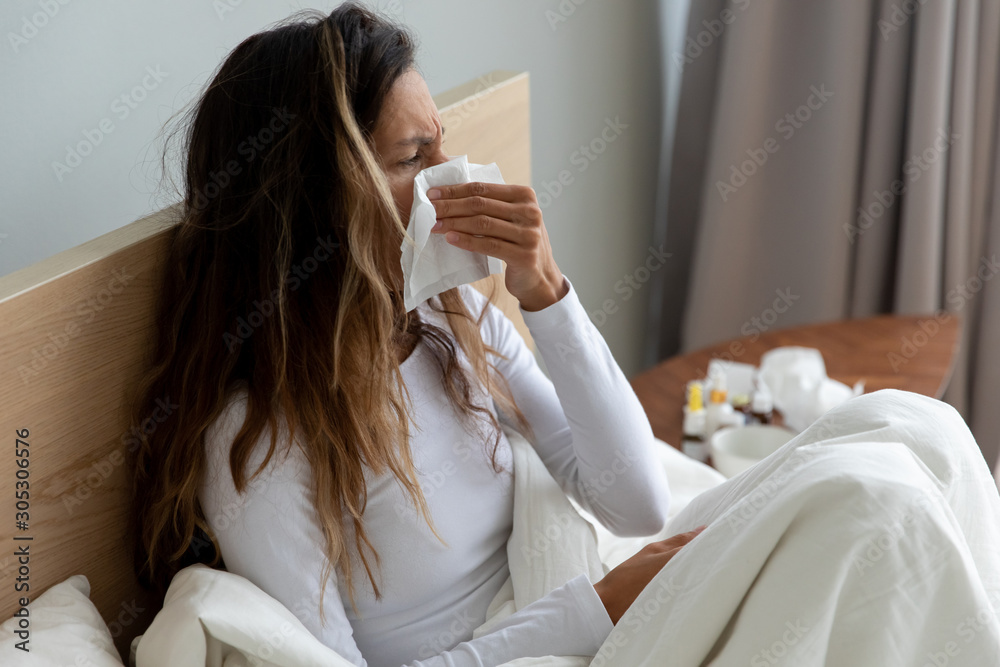 Sick woman holding paper handkerchief wiping blowing runny nose Sick woman holding paper handkerchief wiping blowing runny nose